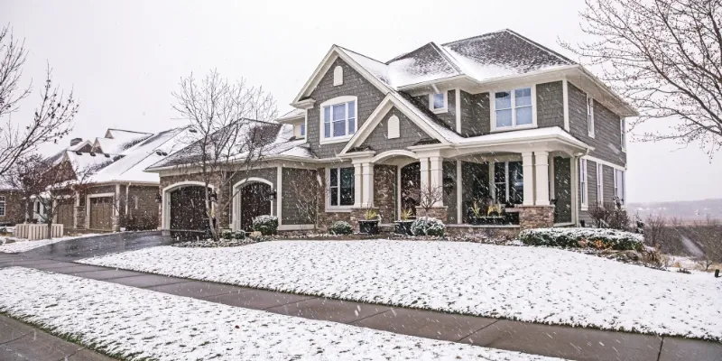 Snow falling in a home's front yard.