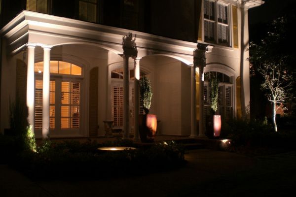 Front of home with landscape night lighting features.